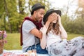 Cheerful young man covered eyes of his girlfriend in park
