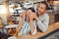 Cheerful young man covering his girlfriends eyes and surprising her while sitting in a cafe. Happy young mixed race Royalty Free Stock Photo