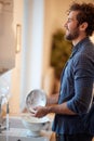 A cheerful young man enjoying housework in the kitchen. Kitchen, housework, quarantin, home Royalty Free Stock Photo