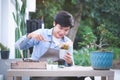 Cheerful young man gardener is transplanting flower in pot. Hobby lifestyle concept Royalty Free Stock Photo