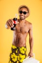 Cheerful young man in hat and sunglasses holding coke bottle Royalty Free Stock Photo