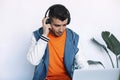 Cheerful young man in headphones listening to the music while sitting at his working place Royalty Free Stock Photo