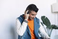 Cheerful young man in headphones listening to the music while sitting at his working place Royalty Free Stock Photo