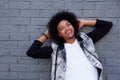 Cheerful young man leaning back against gray wall Royalty Free Stock Photo