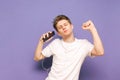 Cheerful young man listens to music on headphones and dances wit Royalty Free Stock Photo