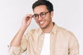 Cheerful young man, looks at someone, wears round trendy eyeglasses, isolated over white studio background. Smart bristle student Royalty Free Stock Photo