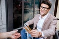 Cheerful young man paying by credit card in outdoor cafe Royalty Free Stock Photo