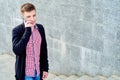 Cheerful young man in plaid shirt and jacket walking up the stairs and talking on cellphone outdoors, free space. Student with mob Royalty Free Stock Photo