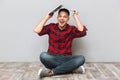 Cheerful young man in plaid sirt holding laptop over head Royalty Free Stock Photo