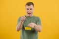 Cheerful young man posing isolated on yellowA handsome man holds the keys to a new car. The concept of buying a new car. Victory