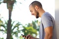 Cheerful young man reading text message on mobile phone Royalty Free Stock Photo