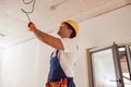 Joyful male electrician repairing electric cable on ceiling Royalty Free Stock Photo