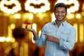 Cheerful young man showing gift box in his hand. Royalty Free Stock Photo