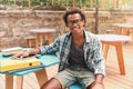 Cheerful young man sitting and smiling in outdoor cafe Royalty Free Stock Photo