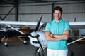 Cheerful young man standing near small plane Royalty Free Stock Photo