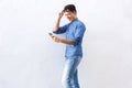 Cheerful young man walking and reading text on cell phone Royalty Free Stock Photo