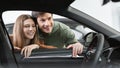 Cheerful young man and woman buying new car, checking automobile salon through window, panorama Royalty Free Stock Photo