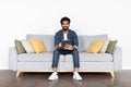 Cheerful young middle eastern guy using digital tablet at home Royalty Free Stock Photo