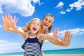 Cheerful young mother and child on seashore having fun time