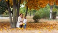Cheerful young mother with her toddler boy playing in autumn park Royalty Free Stock Photo