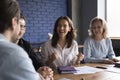 Cheerful young office employee girl meeting with colleagues at table Royalty Free Stock Photo