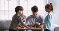 Cheerful young parents and small kids sculpting play dough at home