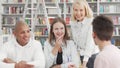 Cheerful young people enjoying talking at the college library after studying Royalty Free Stock Photo