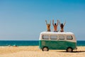 Cheerful young people relaxing on top of retro bus near sea Royalty Free Stock Photo