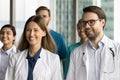 Cheerful young practitioners standing together for shooting, looking away Royalty Free Stock Photo