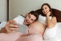 Cheerful young pregnant couple taking selfie Royalty Free Stock Photo