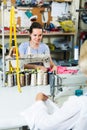 cheerful young professional female tailor using sewing machine Royalty Free Stock Photo