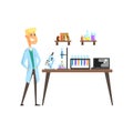 Cheerful young scientist in laboratory. Microscope, test tubes, spirit lamp and laptop on table. Books and glassware