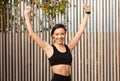 Cheerful young slim caucasian lady in sportswear celebrating victory and great workout result