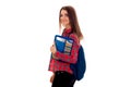 Cheerful young student girl with backpack and folder for notebooks looking at the camera and smiling isolated on white Royalty Free Stock Photo