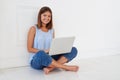 Cheerful young stylish brunette looking at camera and smiling while using her laptop Royalty Free Stock Photo