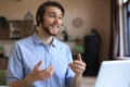 Cheerful young support phone male operator in headset, at workplace while using laptop Royalty Free Stock Photo