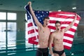 Cheerful young sweimmers raised USA flag Royalty Free Stock Photo