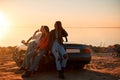 Cheerful young three women standing near cabriolet Royalty Free Stock Photo