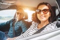 Cheerful young traditional family has a long auto journey and smiling together. Safety riding car concept inside car wide angle Royalty Free Stock Photo