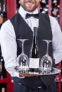 Cheerful young waiter is serving wineglasses for Royalty Free Stock Photo