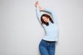 Cheerful young woman with arms raised against gray background Royalty Free Stock Photo