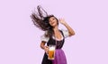 Cheerful young woman in Bavarian dress holding beer