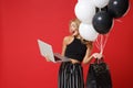 Cheerful young woman in black clothes posing isolated on bright red background. Shopping discount sale concept. Mock up Royalty Free Stock Photo