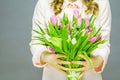 Cheerful young woman with bunny ears and Easter egg basket and tulips Flowers Looking at camera Royalty Free Stock Photo