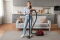 Happy woman standing with vacuum cleaner at home Royalty Free Stock Photo