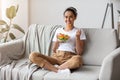 Cheerful young woman eating vegetable salad at home Royalty Free Stock Photo