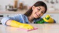 Cheerful young woman cleaning dining table at kitchen Royalty Free Stock Photo