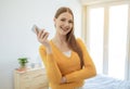 Cheerful Young Woman With Earbuds Earphones Holding Cellphone At Home