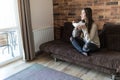 Cheerful young woman eating healthy breakfast while sitting on a couch at home Royalty Free Stock Photo