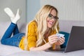 cheerful young woman in eyeglasses holding credit card and using laptop Royalty Free Stock Photo